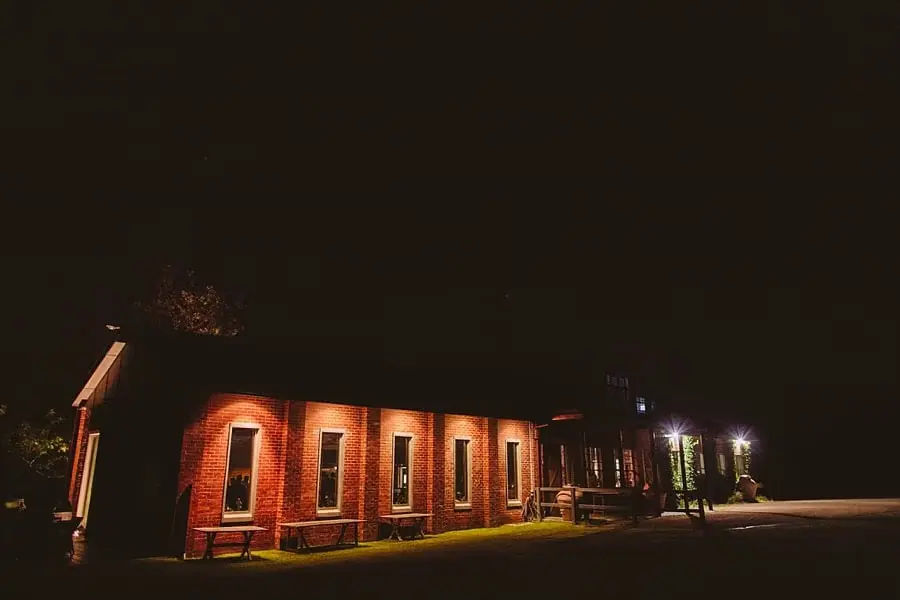 Brick reception building illuminated against a dark night sky.