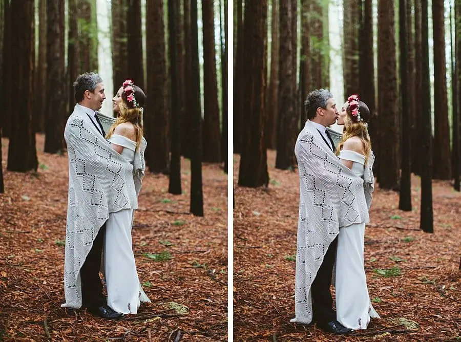 Two photographs of a groom wrapping a grey knit blanket around the bride beneath redwoods.