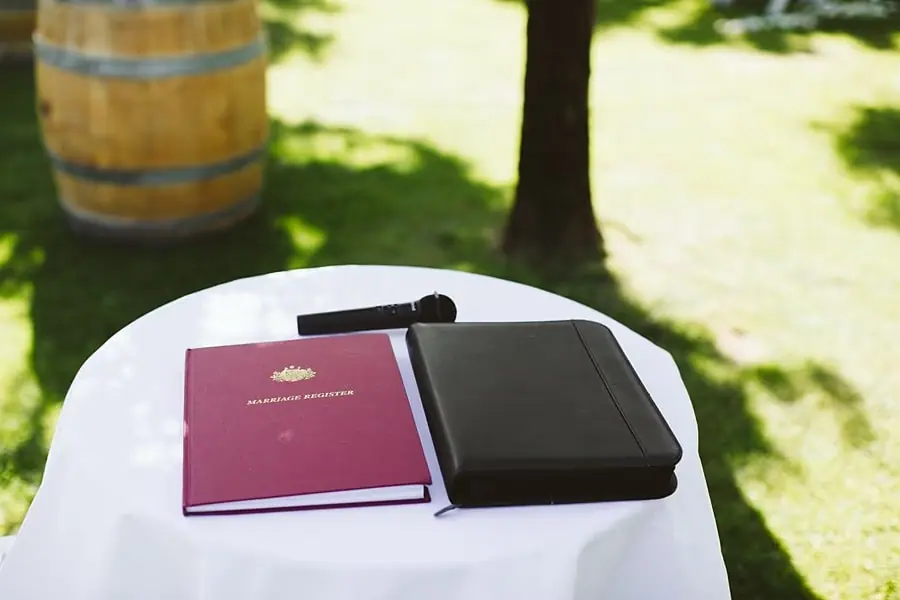 Microphone and ceremony folders resting on a white-covered signing table.