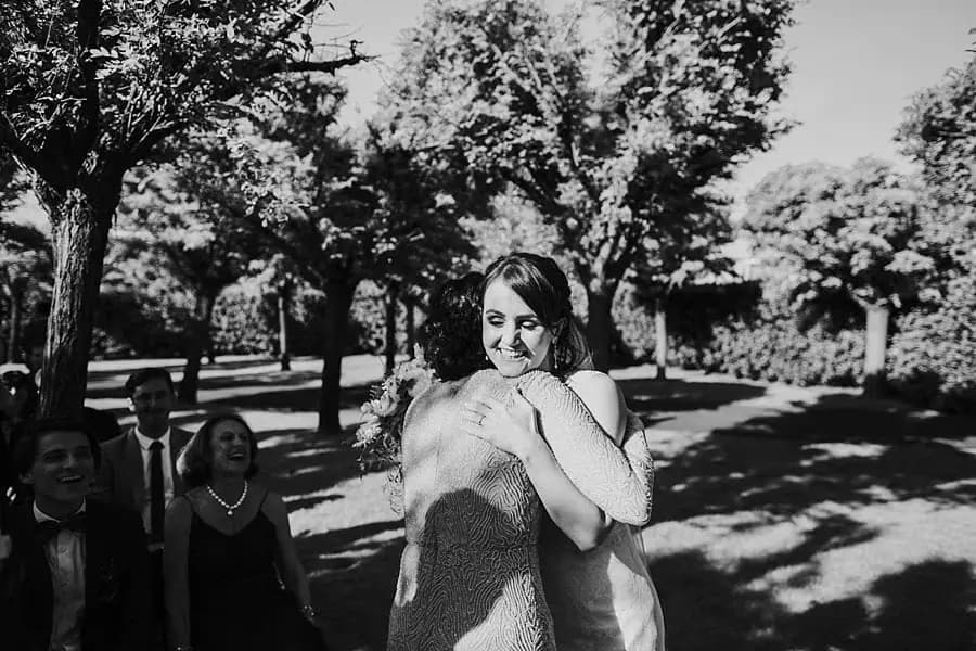 Black-and-white photograph of a seated guest wiping her face during the ceremony.