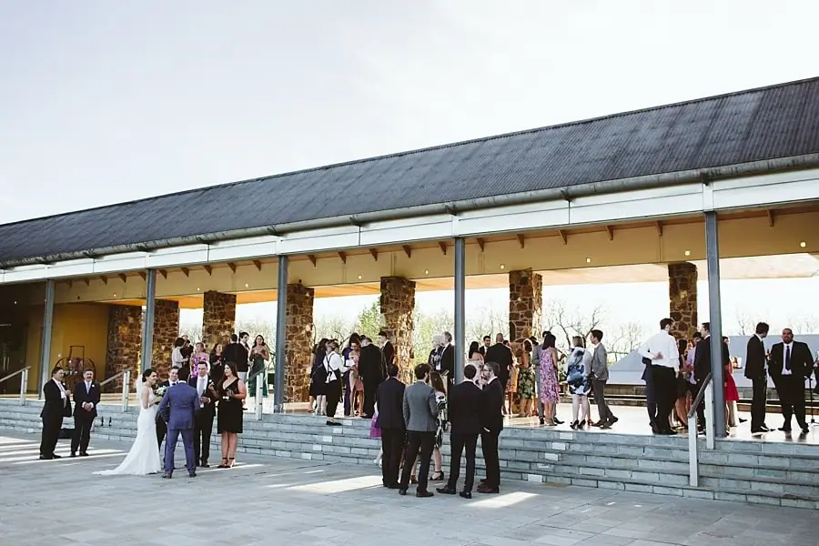 Guests gathered outside a long veranda-fronted reception building.