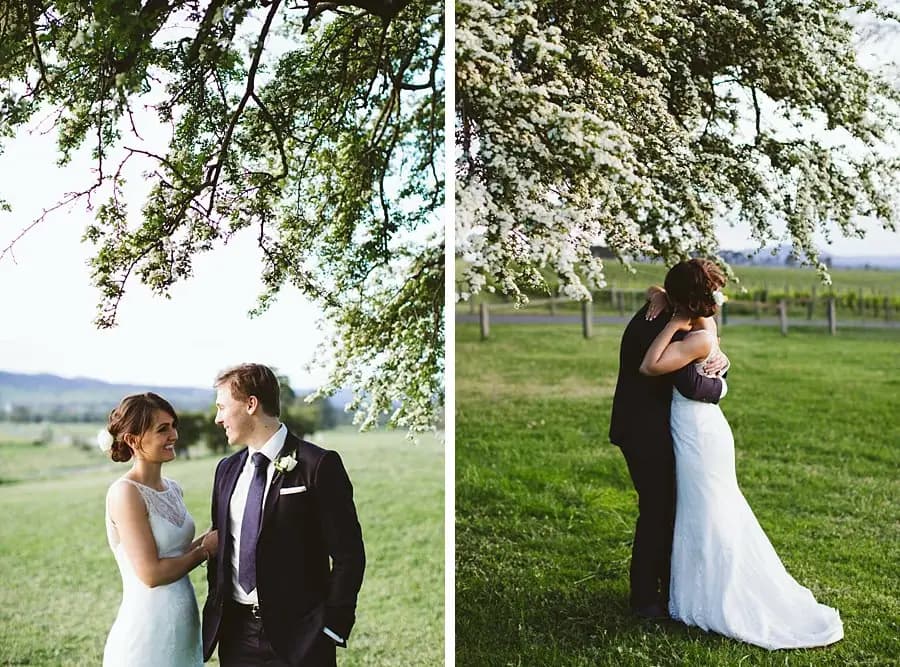 Two photographs of the couple standing and embracing beneath flowering branches.