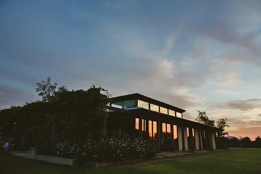 Reception building silhouetted against a pastel sunset sky.