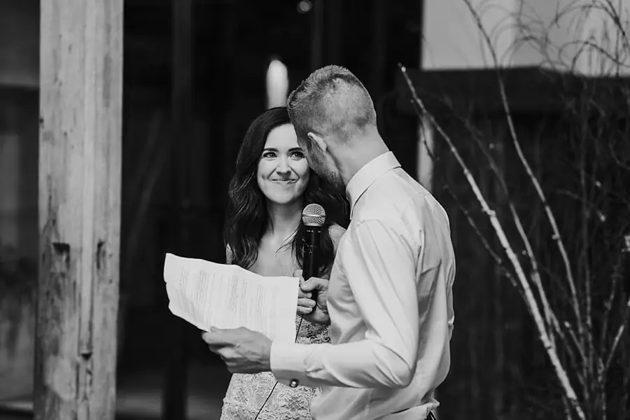Black-and-white photograph of the couple holding speech notes and a microphone.