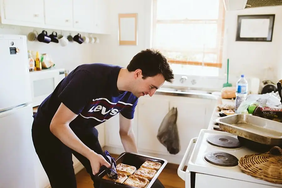 Man preparing food beside a kitchen stove