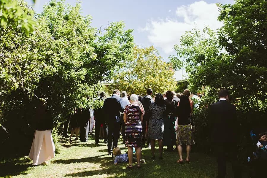 View from behind guests gathered beneath trees for the ceremony