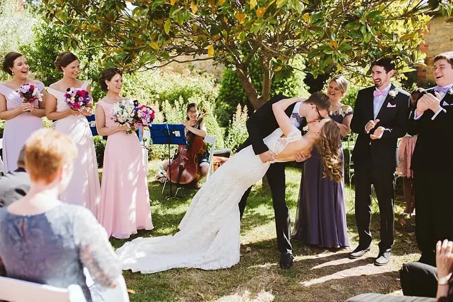 Groom dipping the bride into a kiss during the garden ceremony