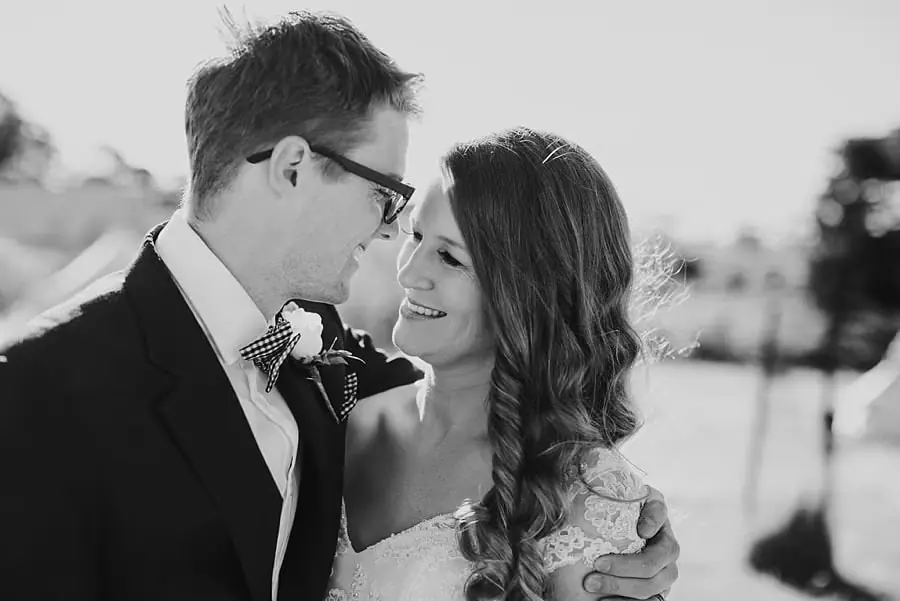 Black-and-white portrait of the bride smiling beside the groom
