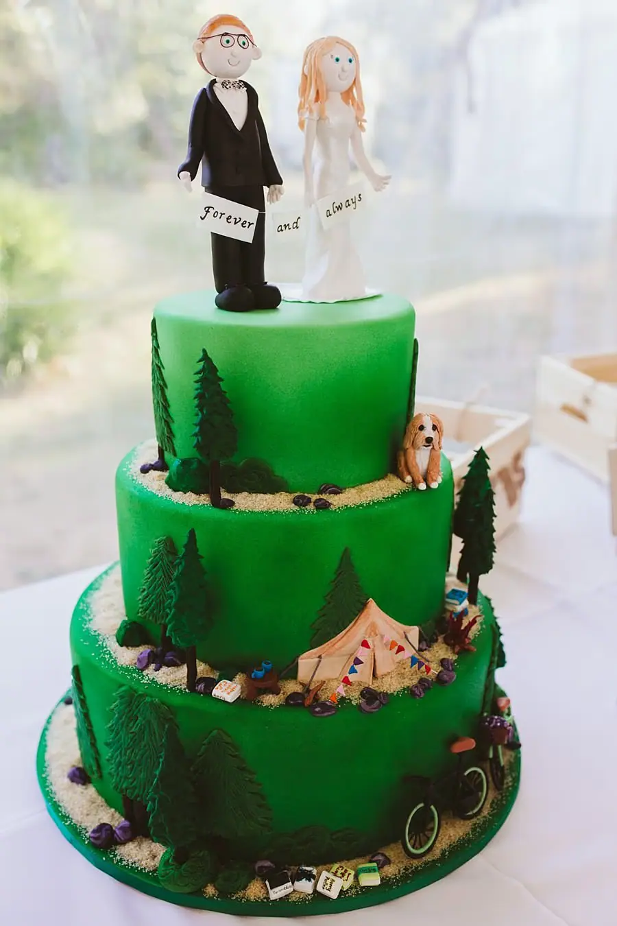 Three-tier green wedding cake with miniature bride and groom figures