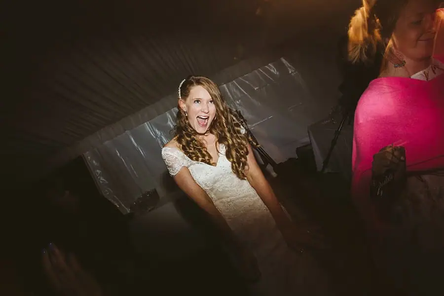 Bride laughing on the dimly lit dance floor