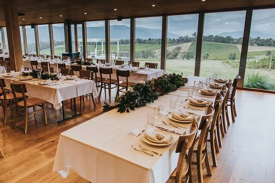 Long reception tables beside large windows overlooking the vineyard.