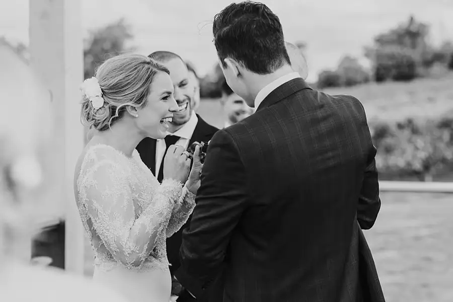 Black-and-white photograph of the bride greeting a man during the ceremony.