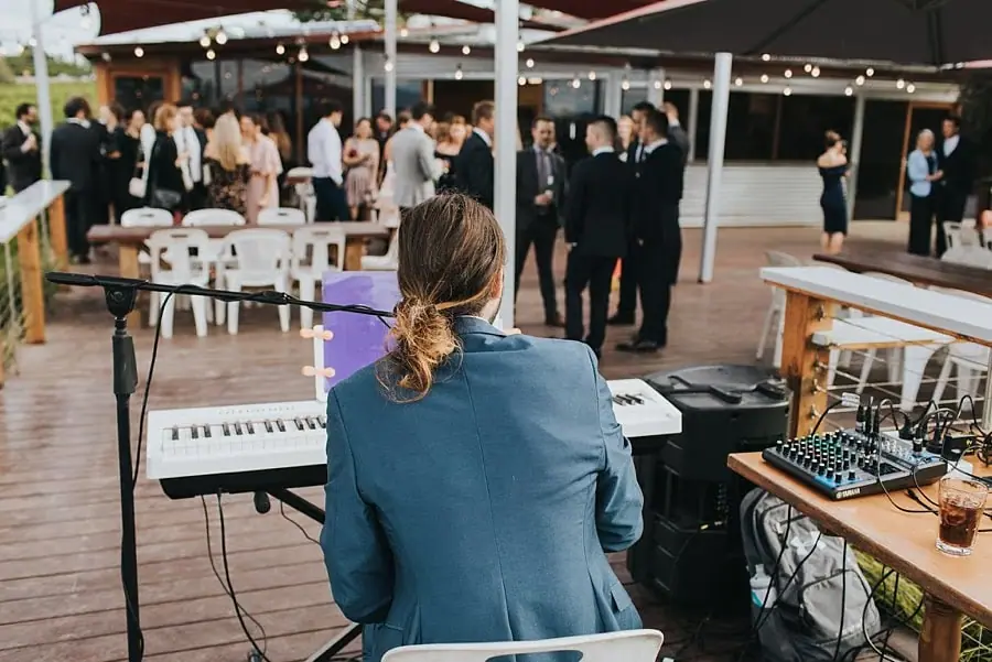 Keyboard musician performing on the deck while guests watch.