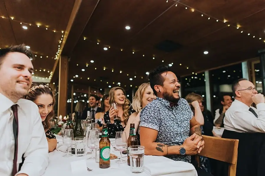 Guests laughing and smiling at a reception table.