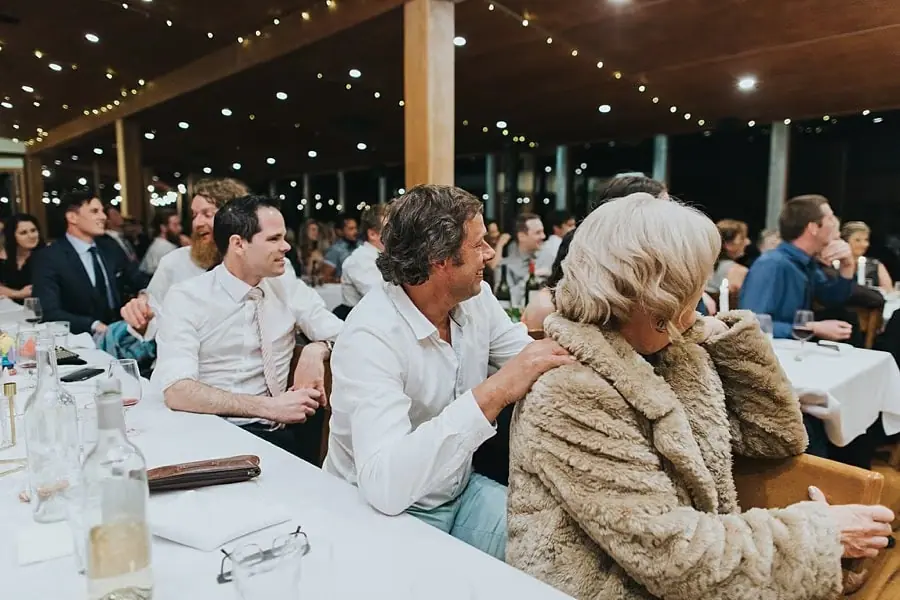 Guests seated around tables and watching the reception speeches.