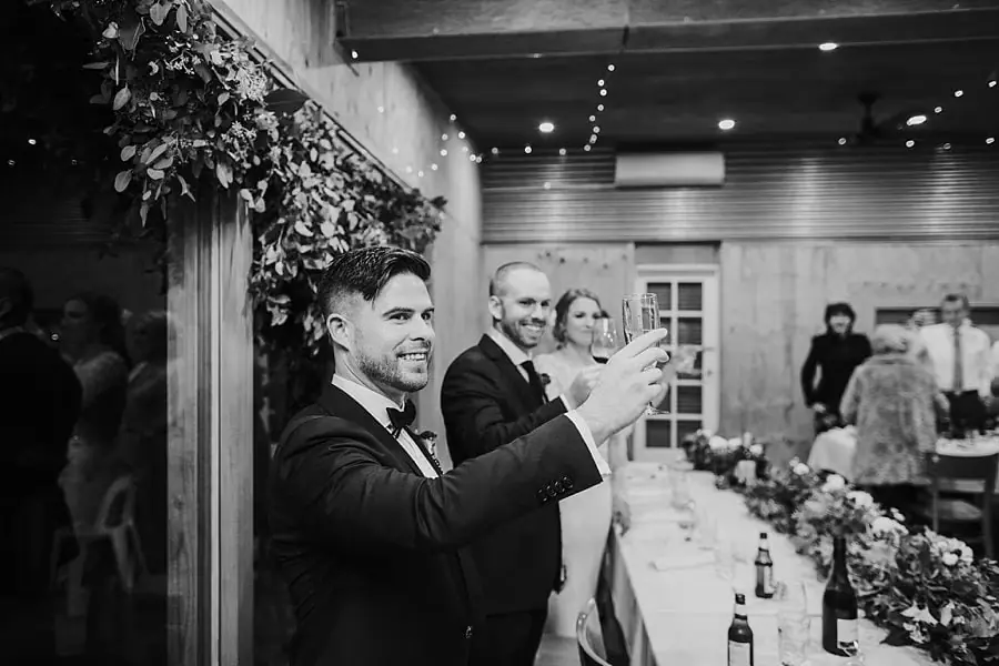 Black-and-white photograph of a man raising a glass for a toast.