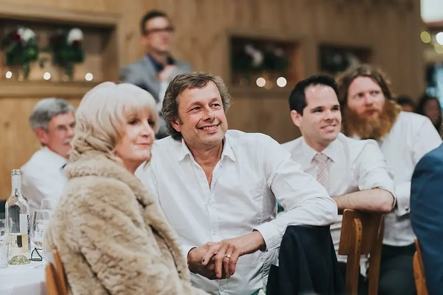 Woman in a pale fur jacket and man beside her smiling at the reception.