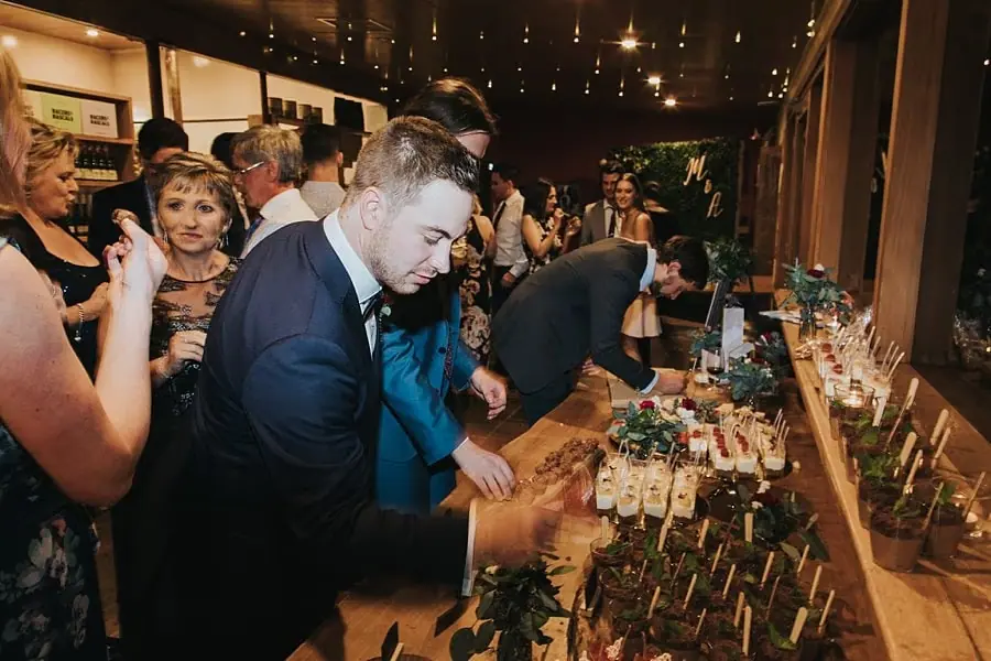 Guests selecting small desserts from the reception dessert table.