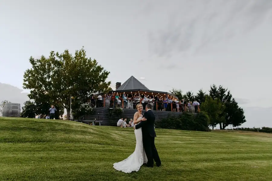 Groom dipping the bride on a lawn below the reception terrace.