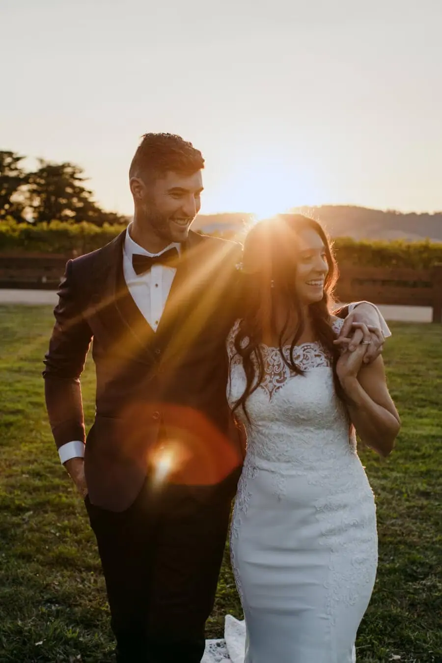 Couple walking together with the setting sun behind them.
