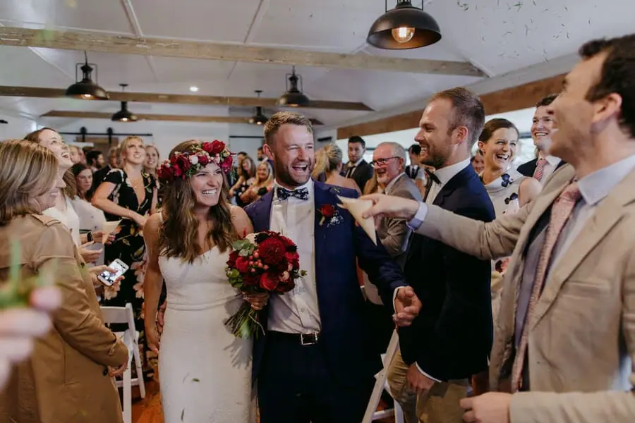 Bride and groom laughing among guests inside the reception.