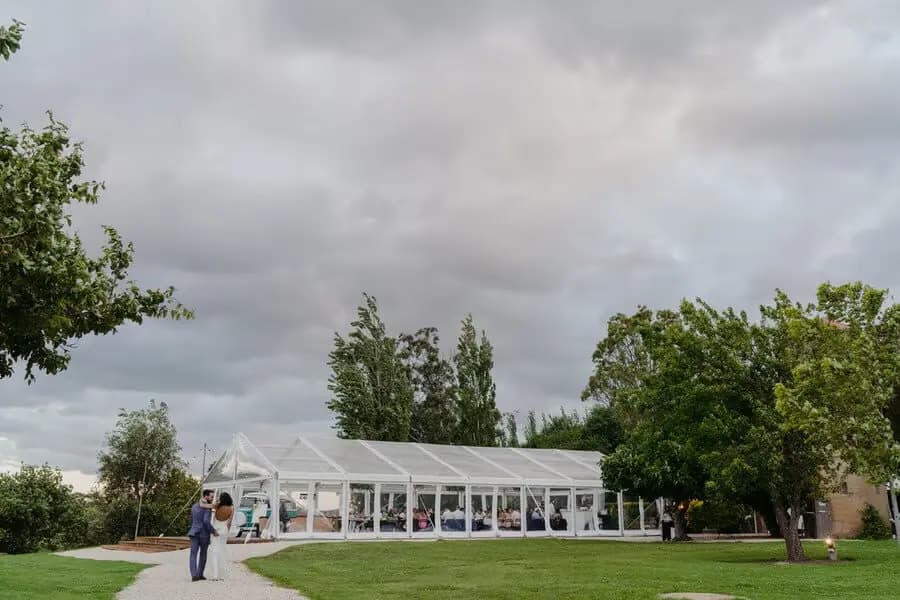 Clear marquee on a green lawn beneath a cloudy sky.