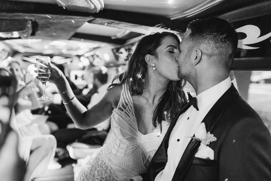 Black-and-white photograph of a couple kissing inside a crowded vehicle.