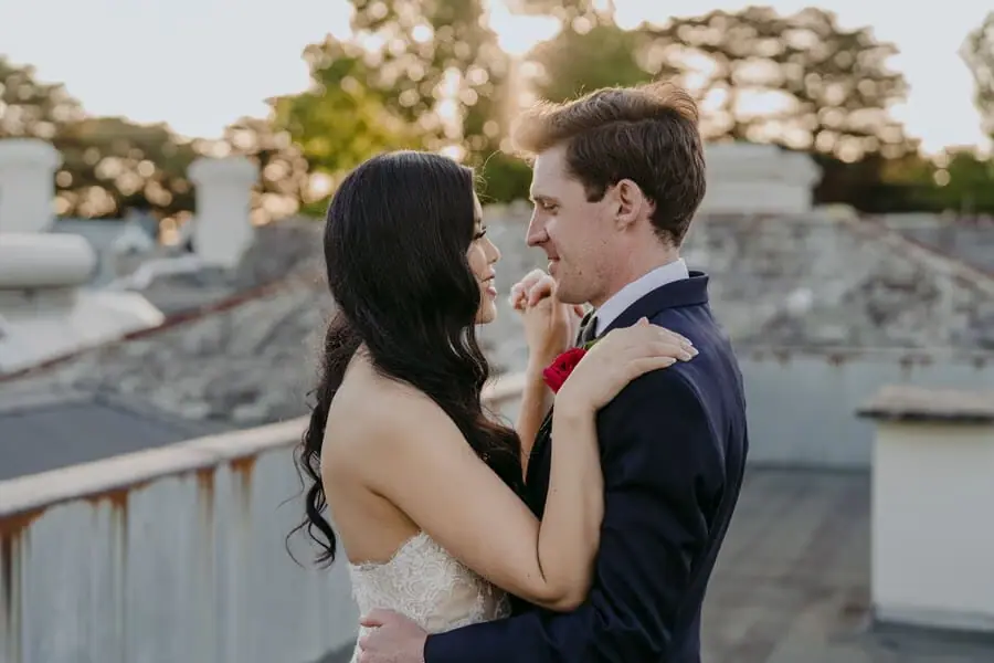 Couple embracing beside a waterfront railing.