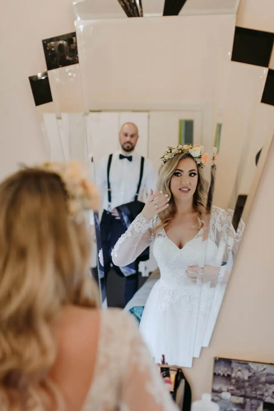 Bride smiling at companions during preparations in a bedroom.