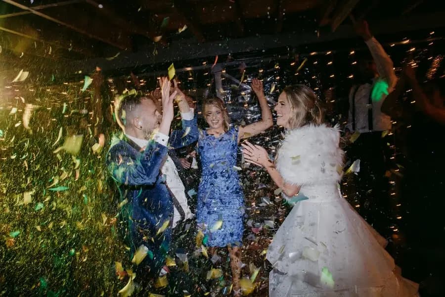 Guests dancing beneath a shower of colourful confetti.