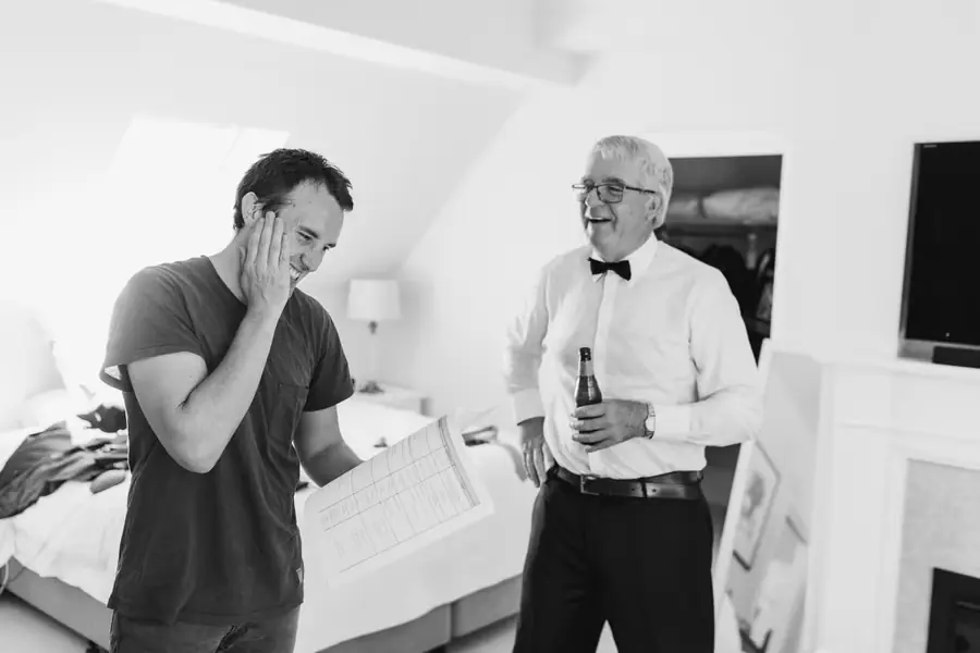 Black and white photograph of a man holding a planning sheet beside an older man