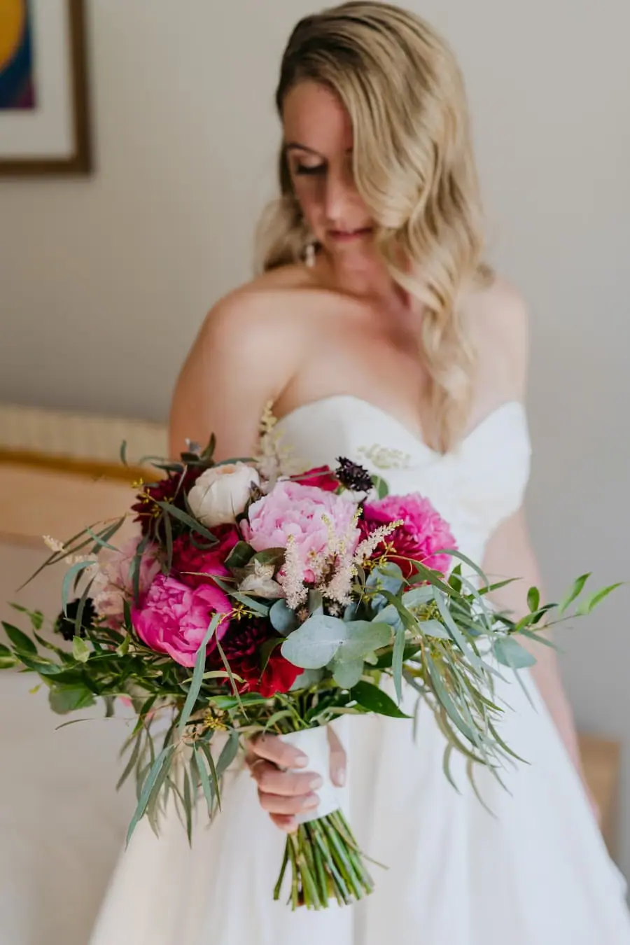Bride looking down at her pink and white flower bouquet