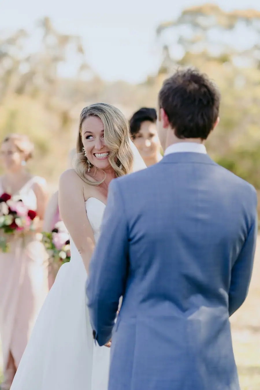 Bride smiling toward the groom during the ceremony