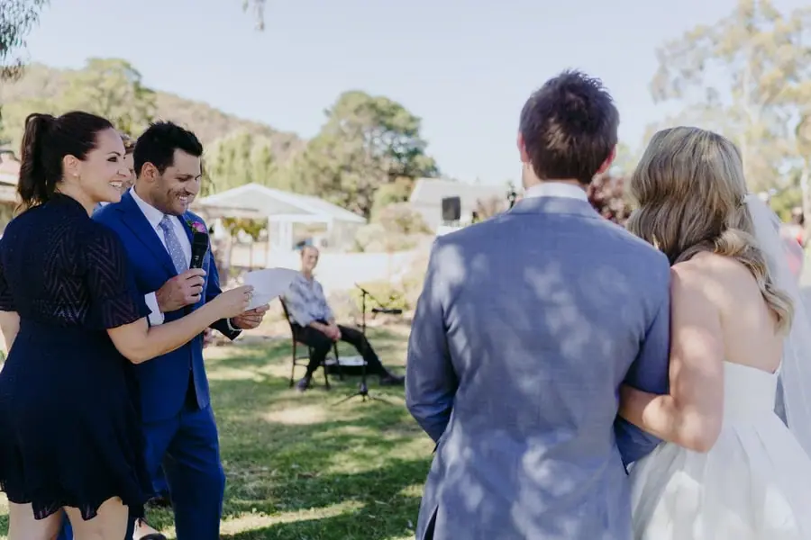 Guest reading beside the couple while a woman stands with him