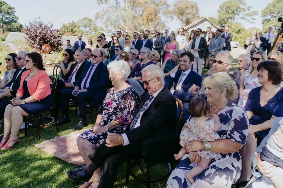 Guests seated and watching the ceremony in the sunshine