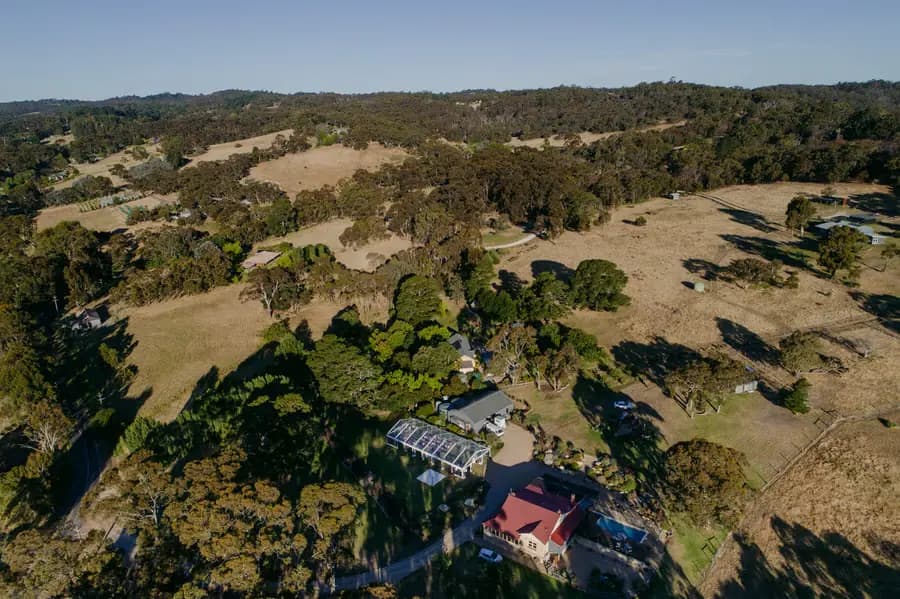 Aerial view of the wedding marquee and house surrounded by wooded hills and fields