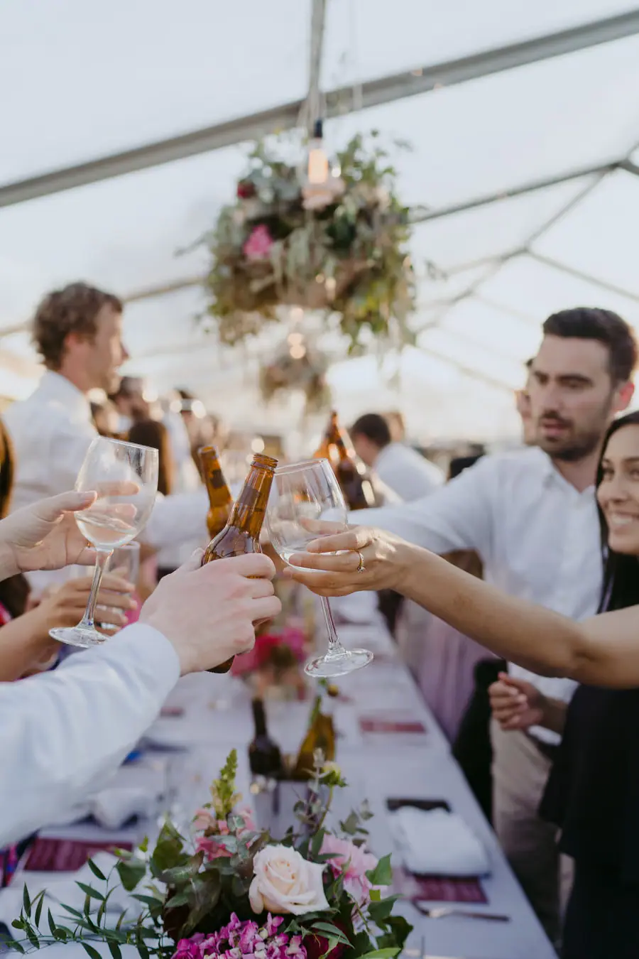 Guests clinking glasses together across a reception table