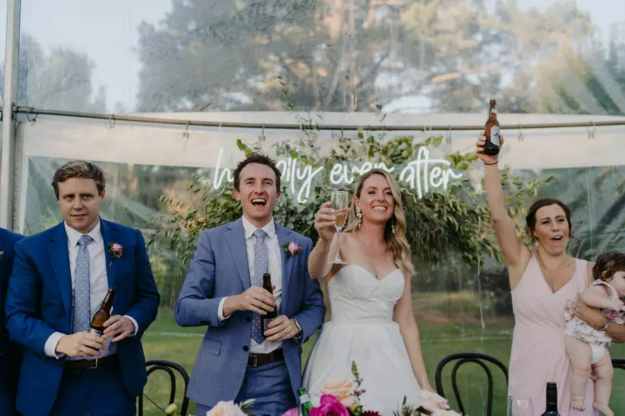 Bride and groom celebrating with the wedding party at the reception table