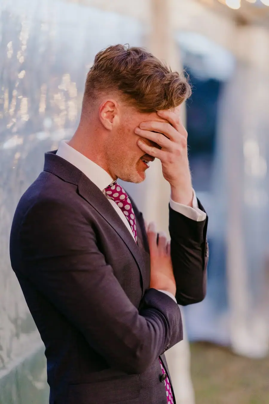 Guest covering his face while laughing during a reception speech