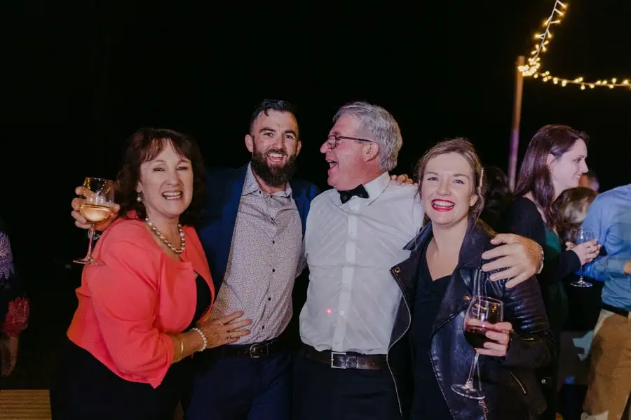 Four guests posing together with drinks at the evening reception