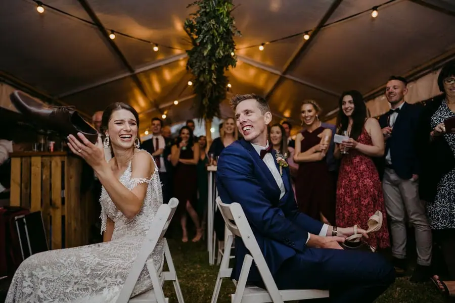 Seated couple reacts to cheering guests inside the reception tent.