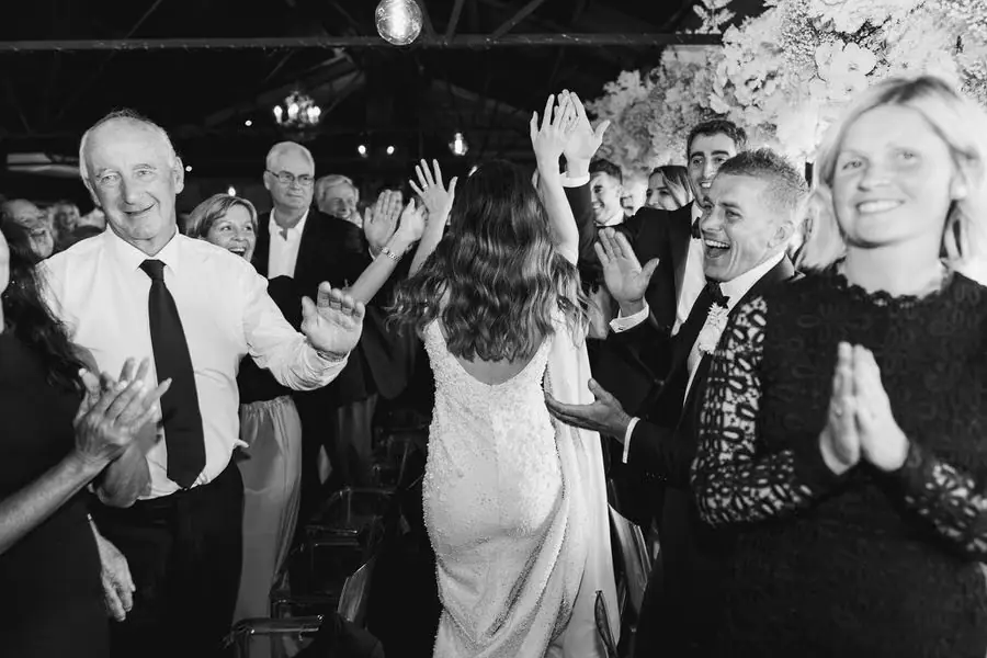 Black and white photograph of guests dancing closely together at the reception.