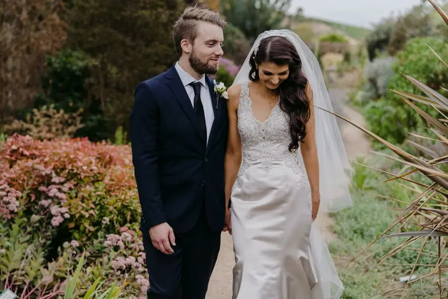 Couple walks together along a landscaped garden path.