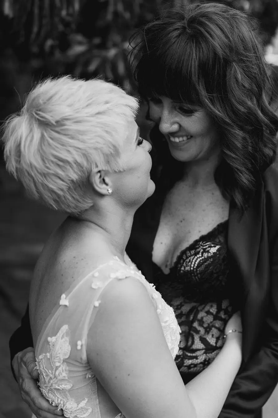 Black and white portrait of two women smiling close together.