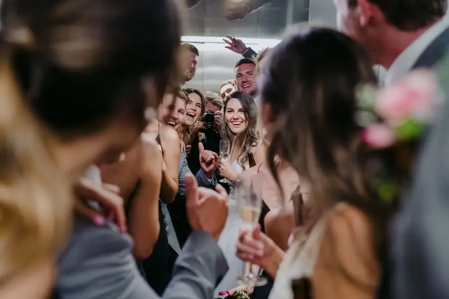 Guests cheer together with raised hands at the reception.