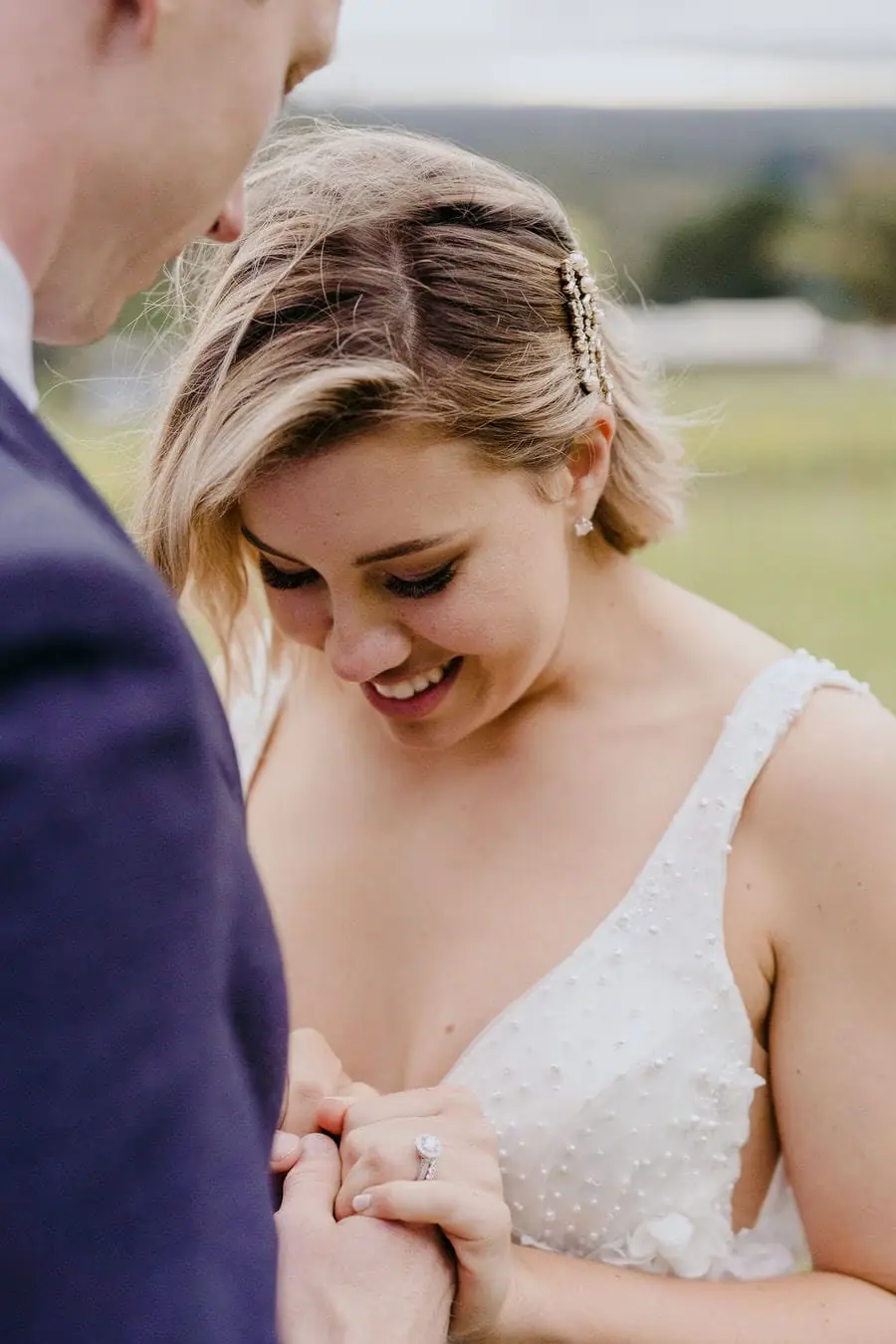 Bride smiles while holding the groom's hands during the ceremony.
