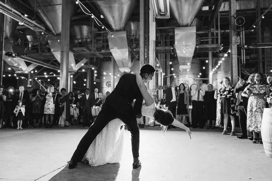 Black and white photograph of the groom dipping the bride during their first dance.