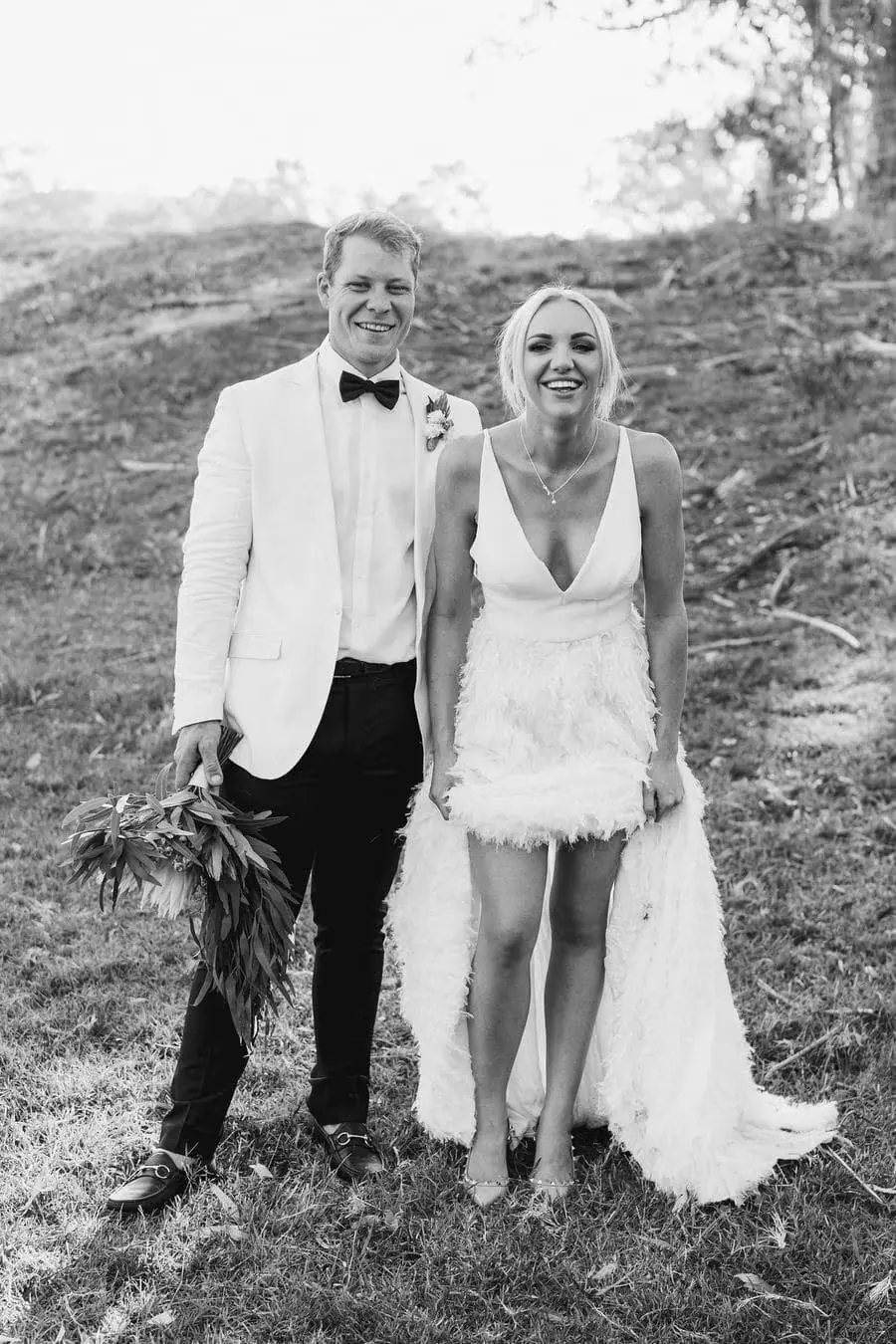 Black and white portrait of the couple standing together on a rocky slope.