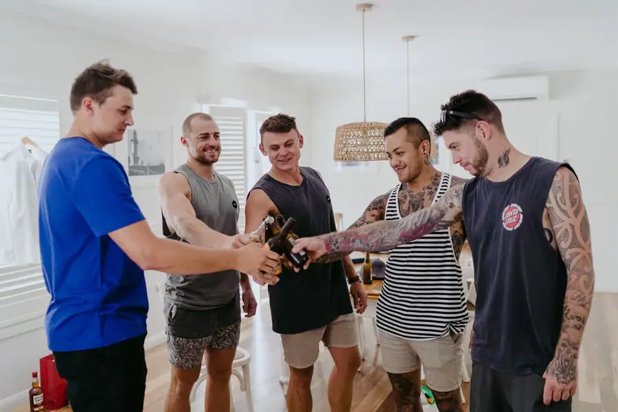 Five men sharing a toast in casual clothes before the wedding