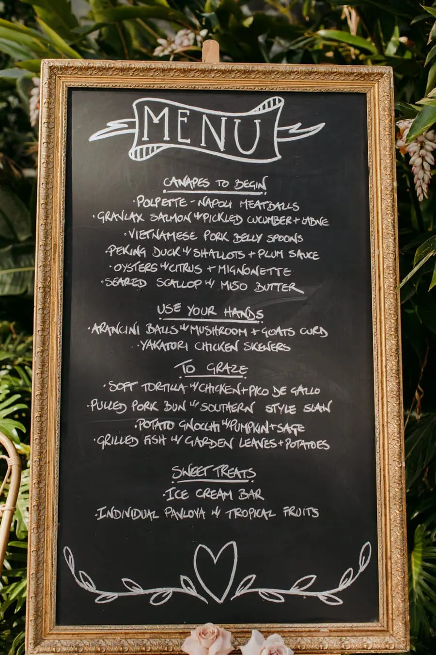 Handwritten wedding menu on a chalkboard in a wooden frame